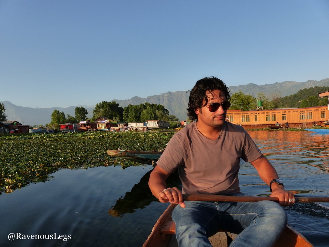 houseboat owner riding shikhara on dal lake, kashmir