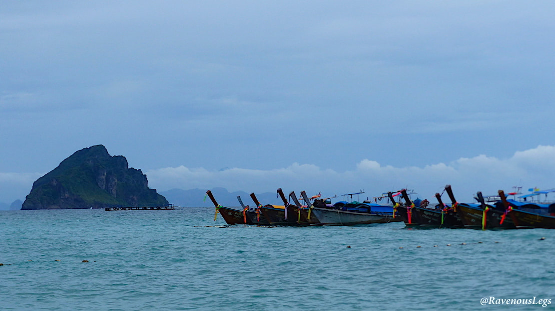 Limestone cliffs and long tailed boats at Phi Phi Islands